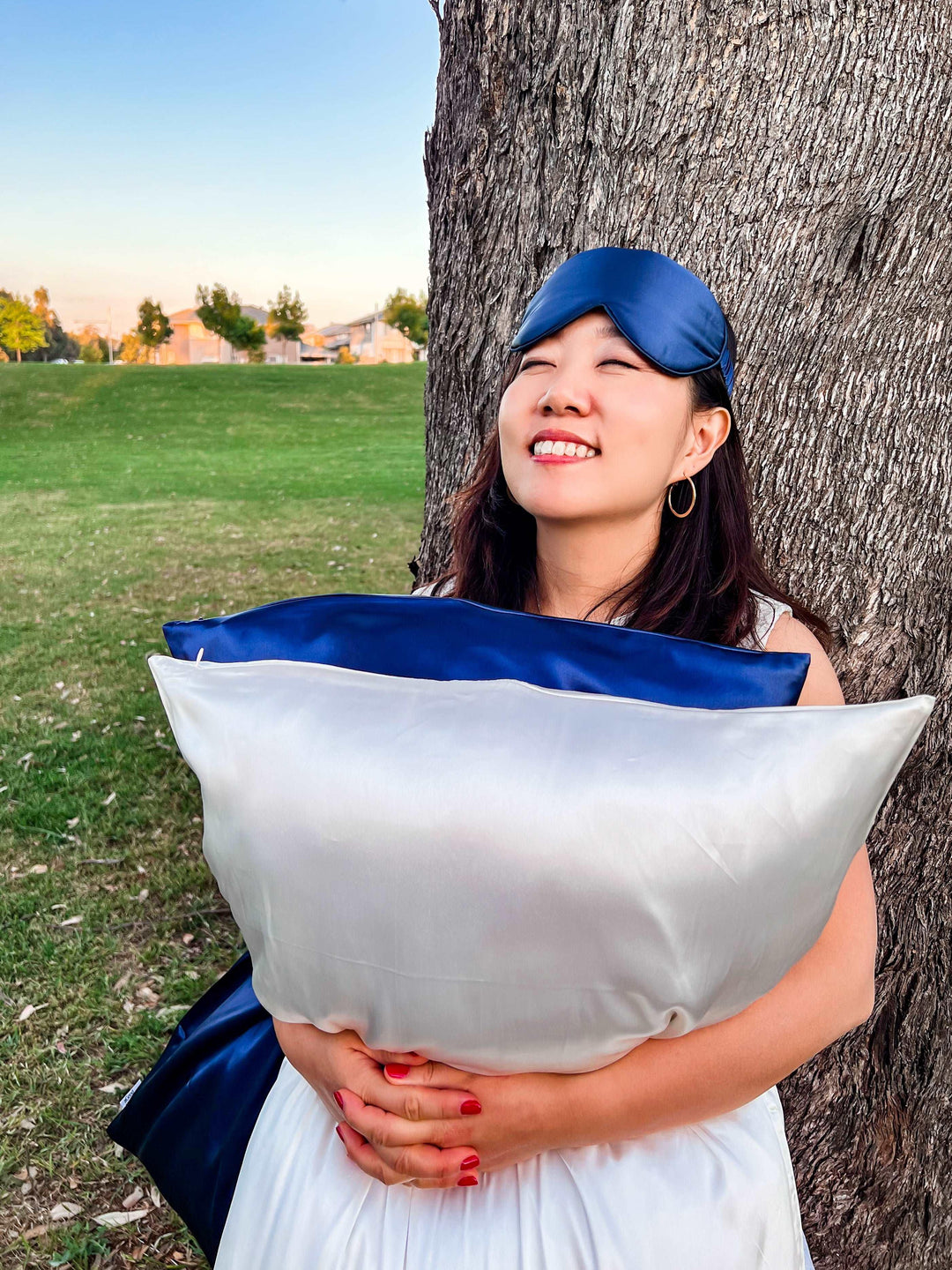 Woman in a white dress showcasing the navy blue silk pillowcase