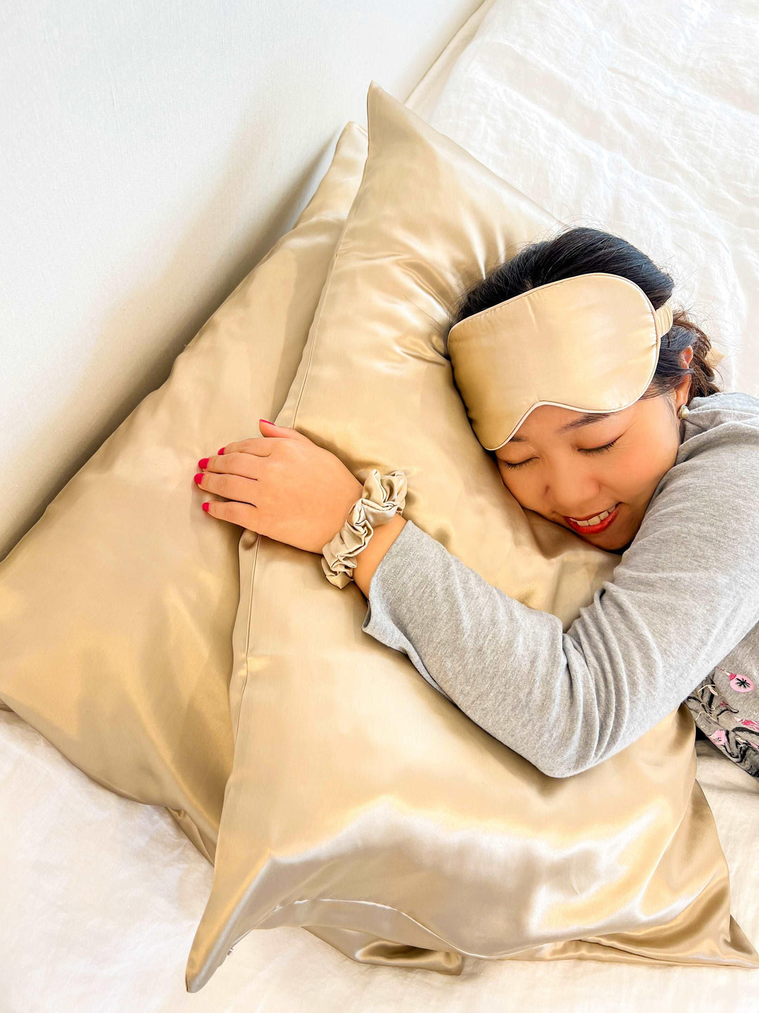 A woman resting on a silk pillow with a Champagne Moon Flower pillowcase