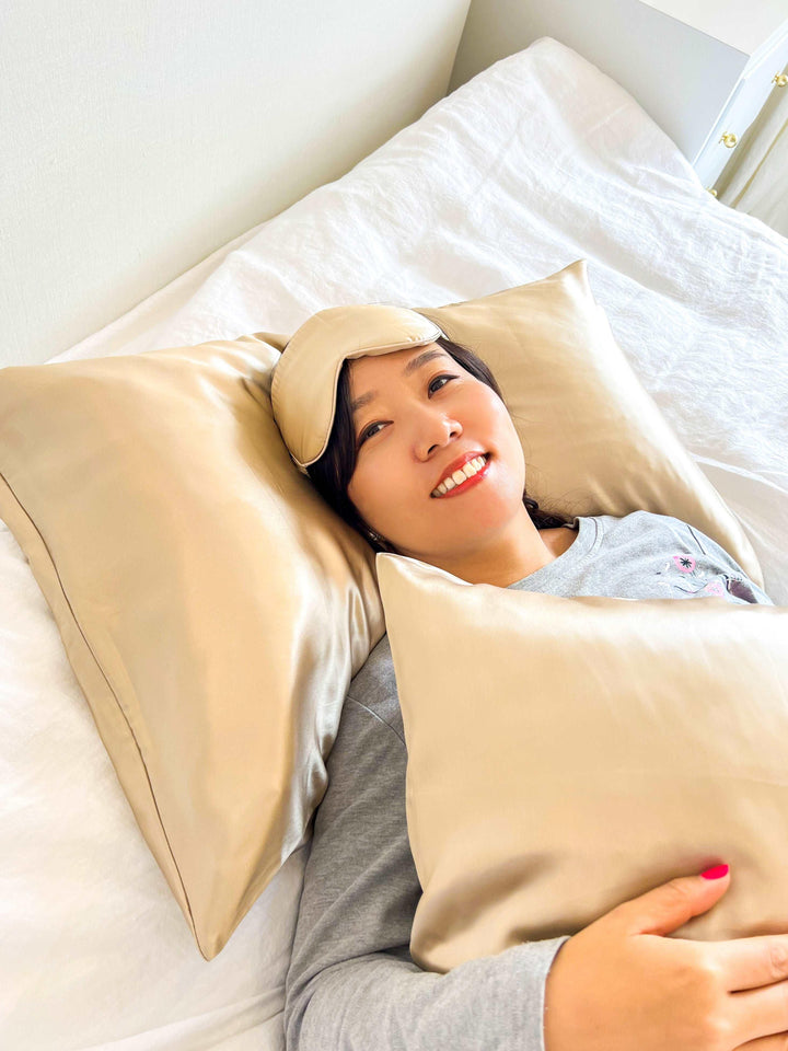 Relaxed woman lying in bed with a champagne silk eye mask