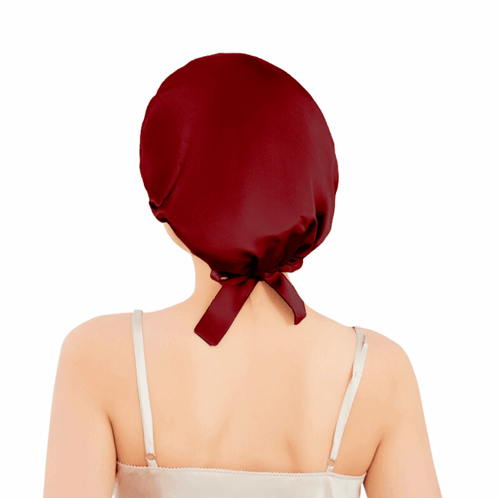 Close-up of a wine red silk bonnet with bow accent