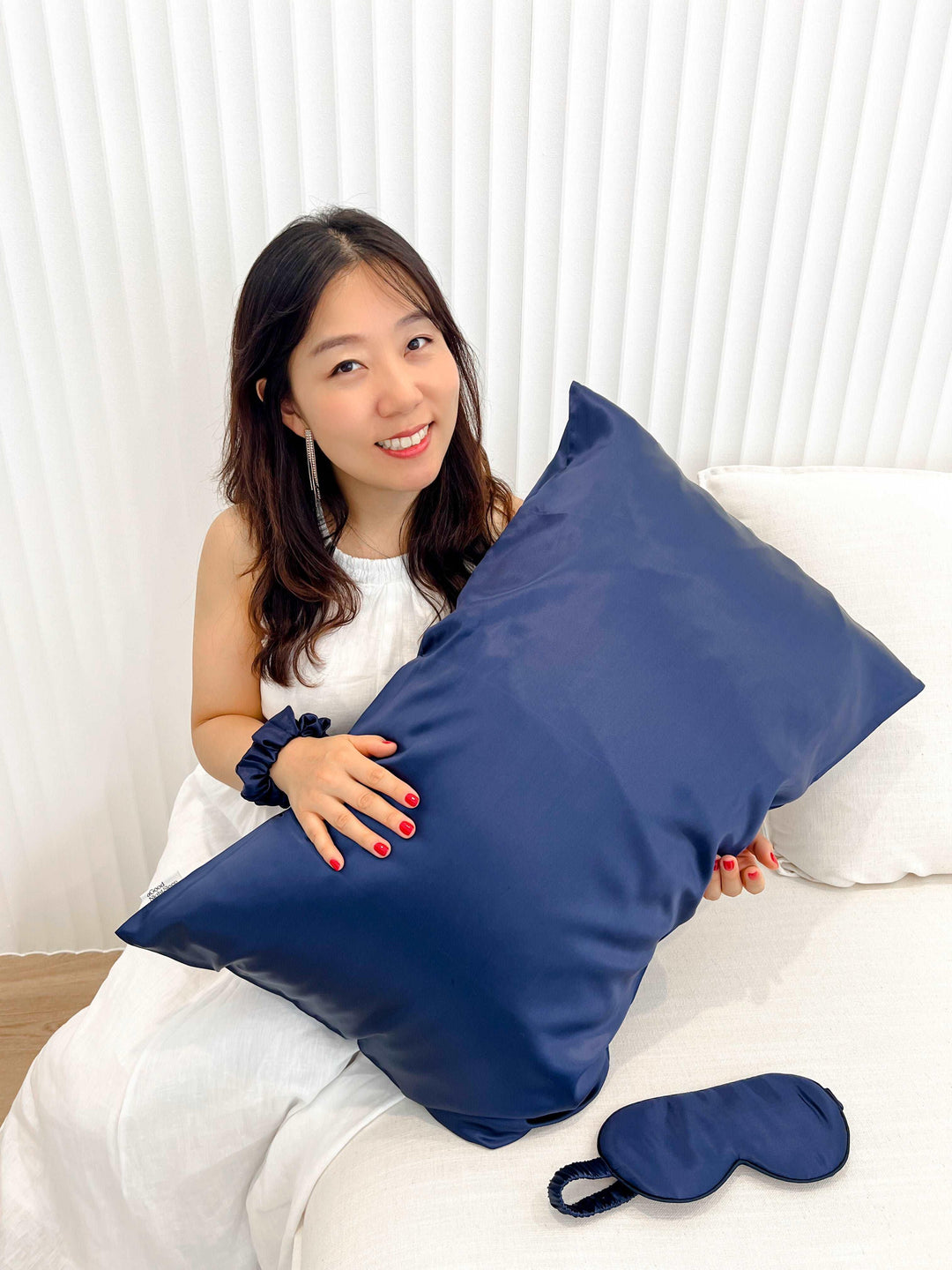 Navy blue silk hair scrunchie held in a woman's hand