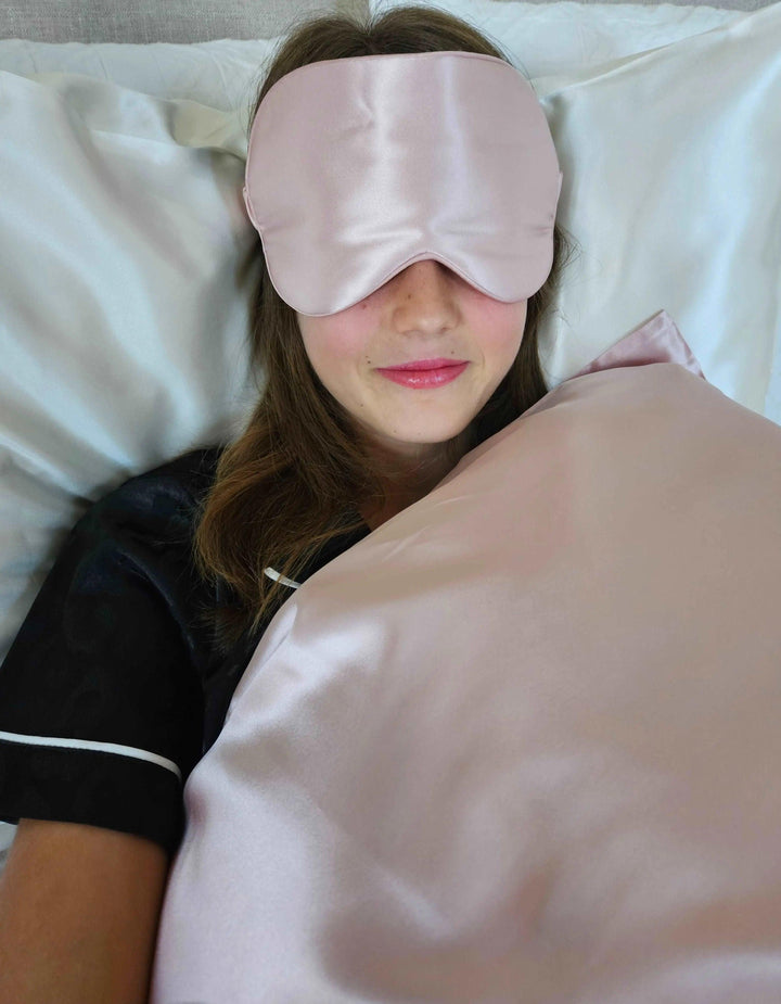 a lady relaxing with a pink silk eye mask 