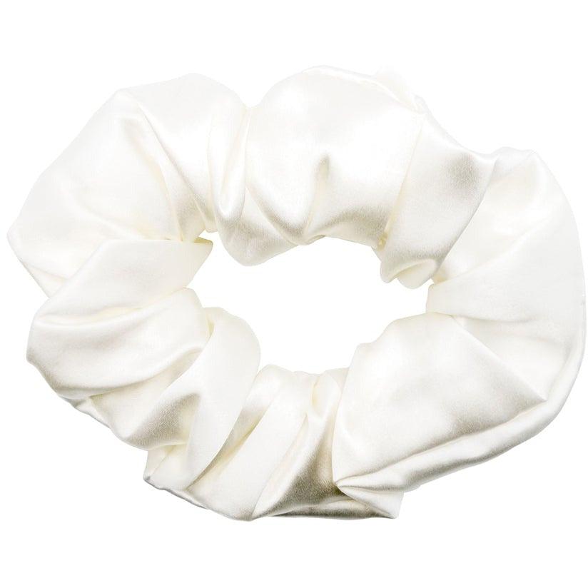 Detail of the white silk scrunchie with a delicate bow from the gift set